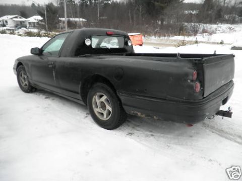 1972 Ford Ranchero - This black pickup truck is viewed from the rear quarter in a snowy environment.
