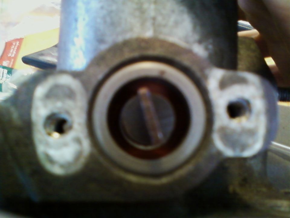 Close-up of a brake master cylinder reservoir cap and mounting holes