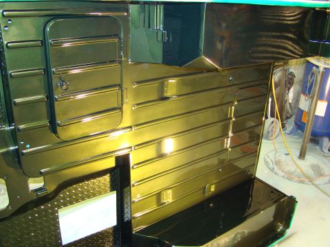 1948 Jeep Wrangler - The interior of a vehicle shows ribbed panels and a storage compartment with a gold finish, possibly undergoing restoration.