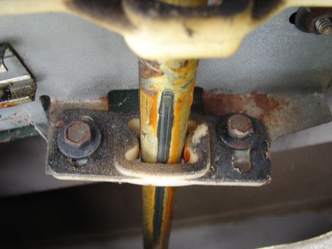1973 Ford Ranchero - Detail of a corroded metal rod and its mounting bracket, suggesting wear and age.