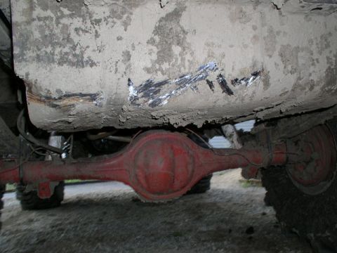1979 Ford Bronco - The underside of a vehicle shows a red differential and heavily soiled body panels, with visible repair marks.