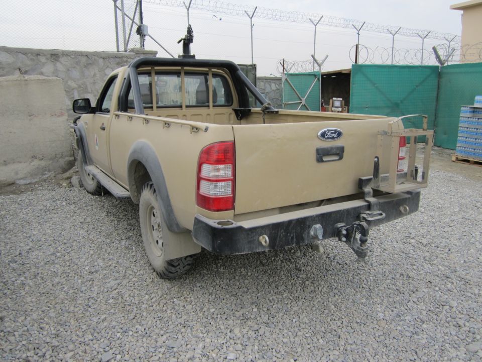 Tan Ford Ranger pickup truck, rear view. Has aftermarket bumper and roll bar