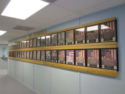 2003 Jeep Wrangler - A long wall features two rows of framed portraits of military personnel, each with an American flag in the background.