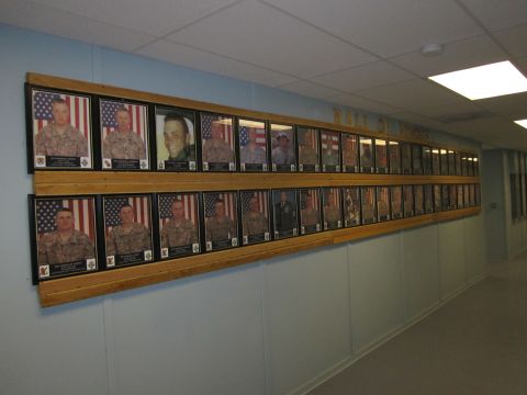 2003 Jeep Wrangler - A hallway displays rows of framed portraits of military personnel, each accompanied by an American flag.