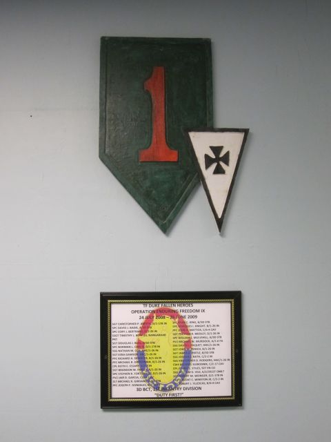 2003 Jeep Wrangler - A memorial plaque and military insignia are displayed on a wall.