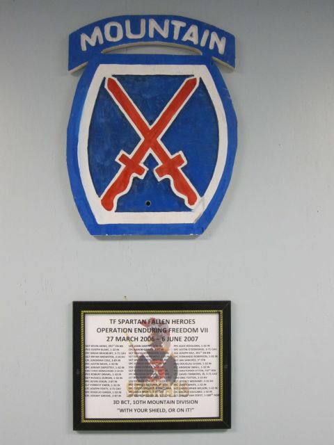 2003 Jeep Wrangler - Photo of a 10th Mountain Division crossed-swords insignia above a framed memorial plaque, not a vehicle document.