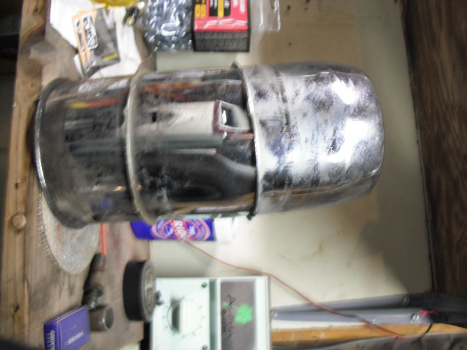 Chrome exhaust pipe with visible rust and grime, mounted on a workbench