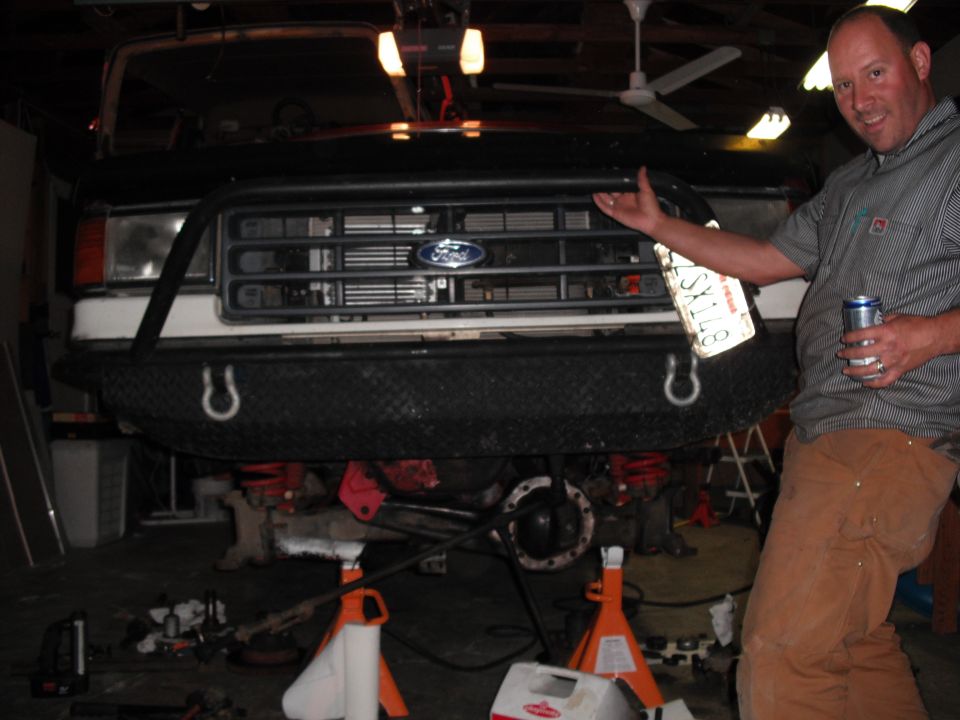 1991 Ford Bronco front end with custom bumper and man holding license plate