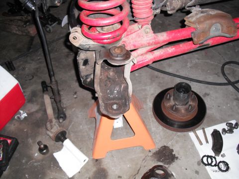 1991 Ford Bronco - Disassembled vehicle suspension and brake parts are shown, including a hub, rotor, ball joint, and coil spring.
