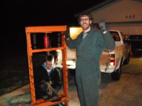 1991 Ford Bronco - Two men are working with a hydraulic press next to a pickup truck in a driveway at night.
