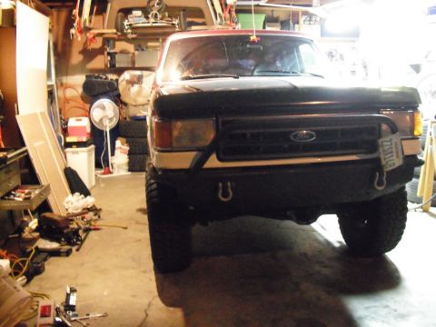 1991 Ford Bronco - Front view of a 1991 Ford Bronco, likely in a garage, an aftermarket bumper and visible license plate.