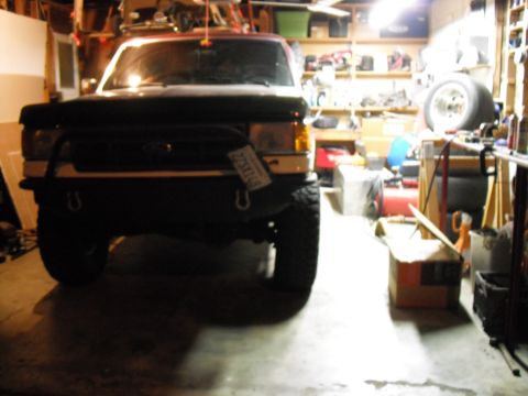 1991 Ford Bronco - Front view of a 1991 Ford Bronco parked in a garage, showing its grille and bumper.