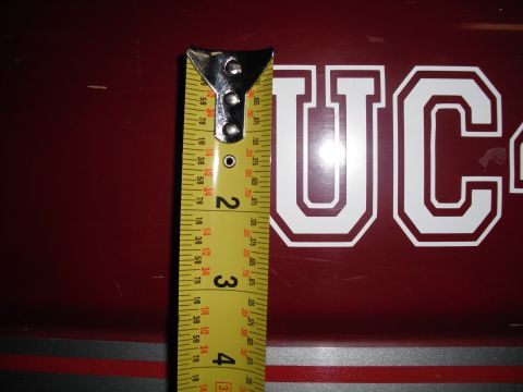 1991 Ford Bronco - A tape measure is placed next to white UC stickers on a maroon surface.
