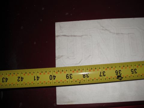 1991 Ford Bronco - A sticker is being measured with a tape measure. The sticker has faint outlines of letters.