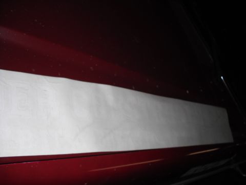 1991 Ford Bronco - A white sticker is affixed to the side of a dark red vehicle.