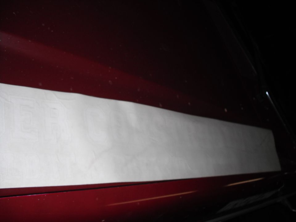 White sticker on dark red vehicle side panel