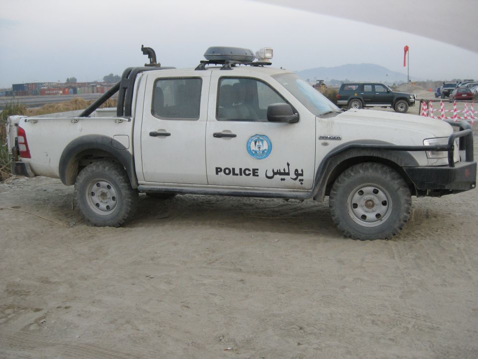 White Ford Ranger pickup truck with police markings, snorkel, roof rack, and bull bar
