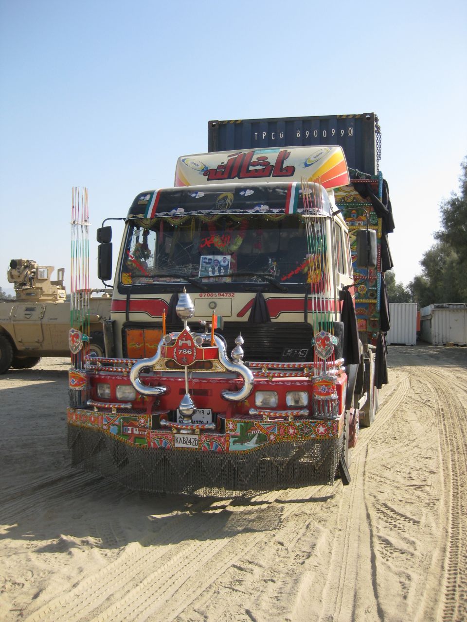 Front view of a heavily decorated truck with Arabic script and colorful designs. License plate KAB2420