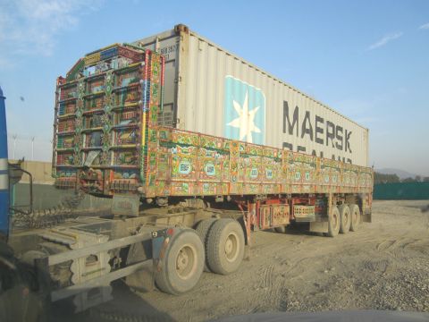 2003 Jeep Wrangler - A heavily decorated truck carries a Maersk shipping container under a clear sky.