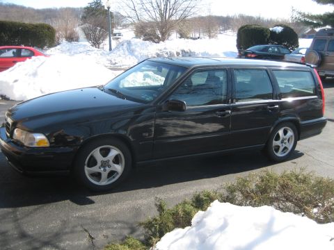 1993 Ford Probe - A black Volvo wagon is parked in a snowy area, with other vehicles visible in the background.
