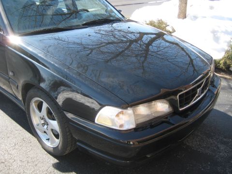 1993 Ford Probe - Black Volvo sedan front corner with a chrome grille and headlight visible.