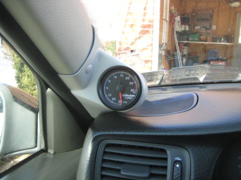 1993 Ford Probe - A GReddy turbo gauge is mounted on the interior pillar of a vehicle.