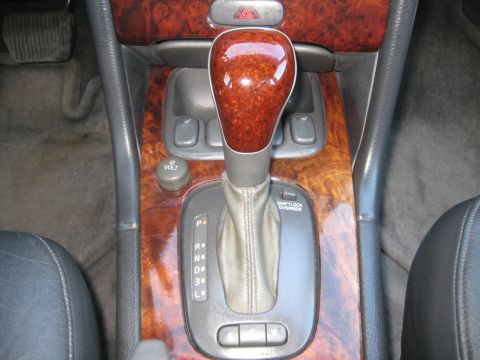 1993 Ford Probe - Close-up of a car's center console an automatic shifter and wood grain trim.