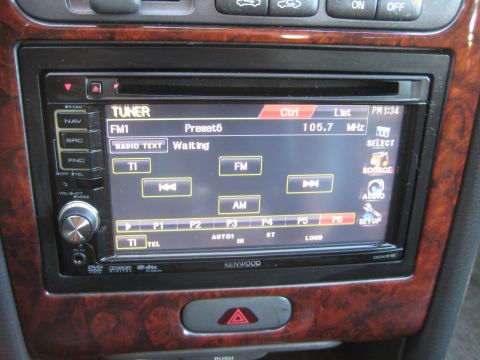 1993 Ford Probe - The interior of a car shows a Kenwood infotainment system with wood grain trim surrounding the display.