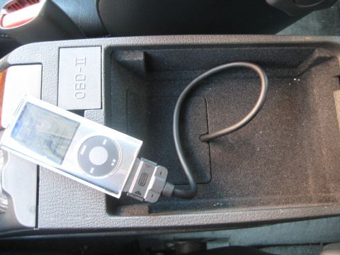 1993 Ford Probe - An iPod is connected to the OBD-II port inside a vehicle's center console.