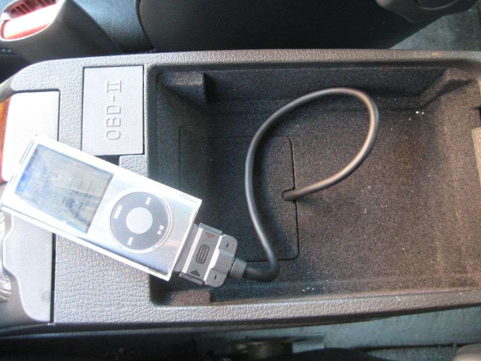 Interior car console with OBD-II port and silver iPod connected by cable
