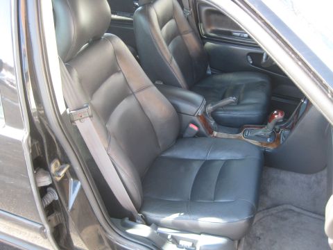 1993 Ford Probe - Interior view of a car's front seats and center console, showing black leather upholstery.