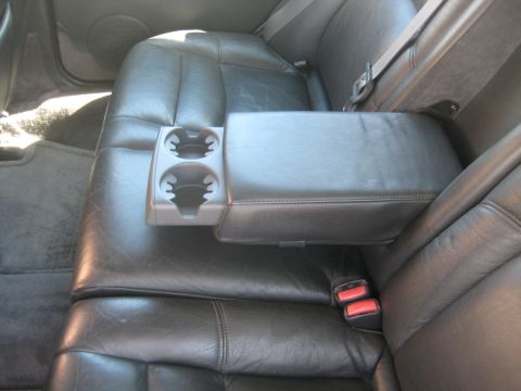 1993 Ford Probe - The interior of a car shows the back seats, complete with an armrest and dual cup holders.