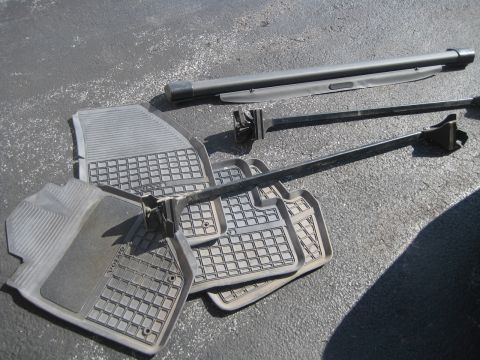 1993 Ford Probe - Car floor mats and a cargo cover are laid out on an asphalt surface.