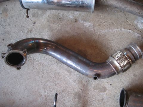 1993 Ford Probe - Close-up of a metal exhaust pipe section with a braided flex joint.