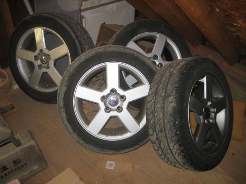 1993 Ford Probe - Several tires and wheels are stored indoors on a wooden floor.