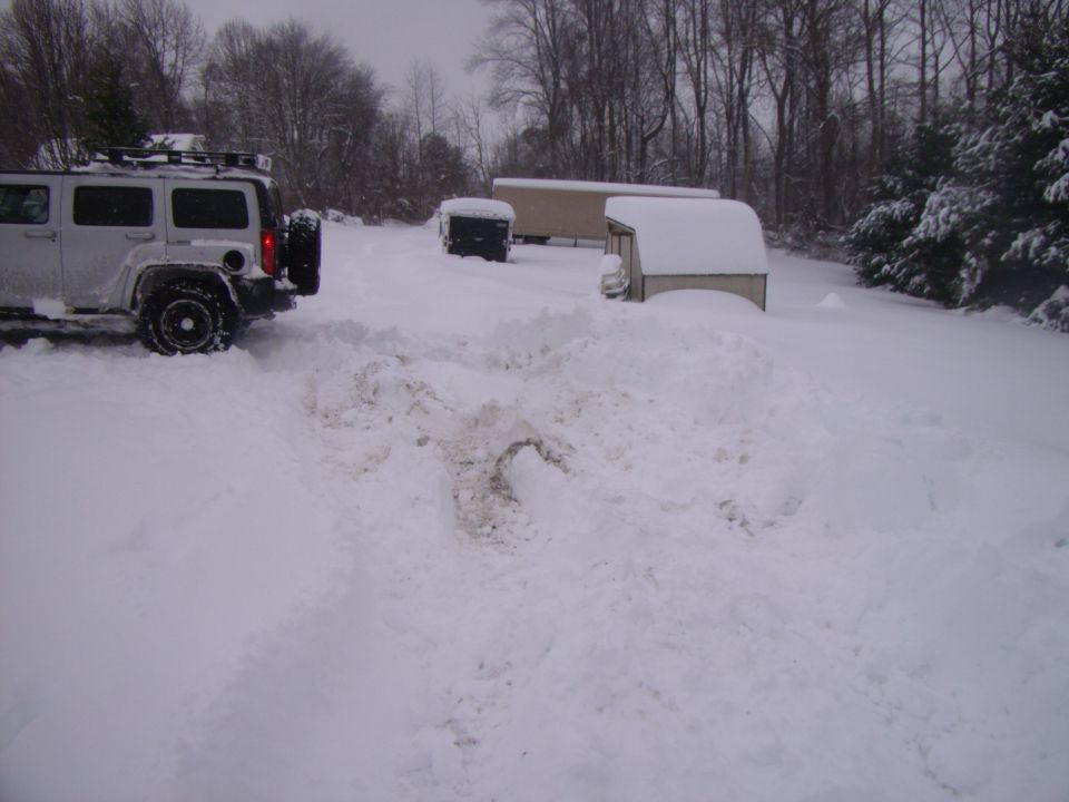 Silver SUV with roof rack and spare tire in snow