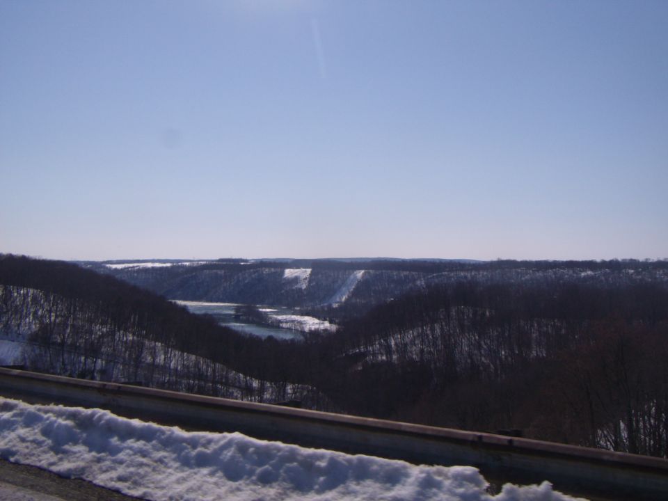snowy hills and a lake under a clear blue sky