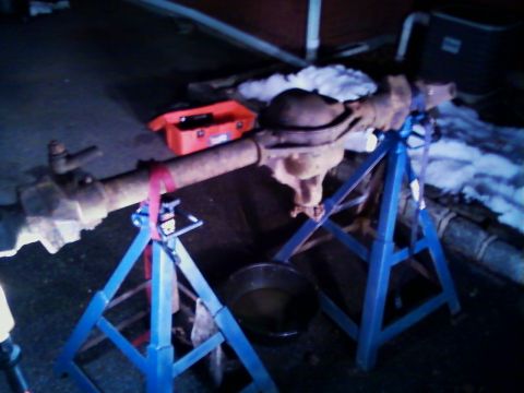 1990 Ford Bronco - A vehicle axle assembly is shown on jack stands, with a red toolbox and a bucket visible.