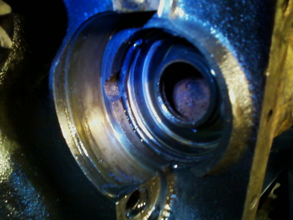 Close-up of a rusty metal part with blue and yellow accents, showing internal spiral details
