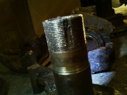 1990 Ford Bronco - Close-up of a damaged axle shaft, showing significant wear on the threads.