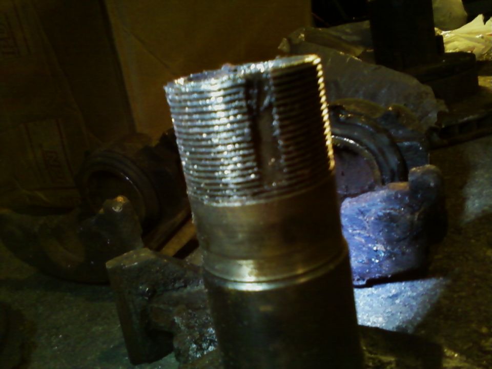 Close-up of a damaged, threaded axle shaft with visible wear and tear