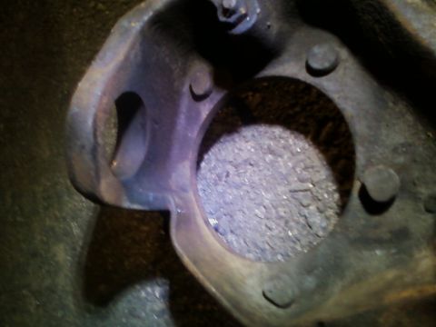 1990 Ford Bronco - A close-up view of a vehicle's axle housing part, showing wear and debris within a circular opening.