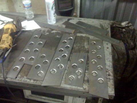 1994 Jeep YJ - Metal fabrication parts and tools laid out on a workbench.