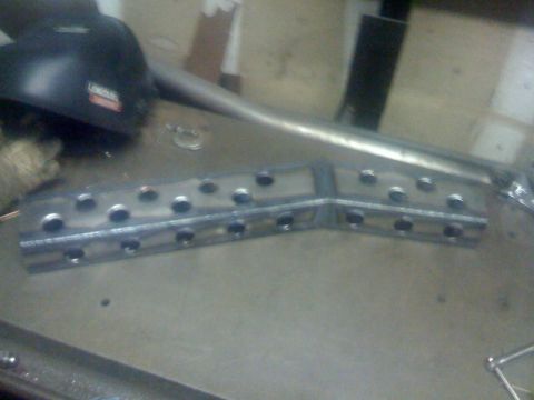 1994 Jeep YJ - Metal bracket being worked on with a Lincoln welding helmet nearby.