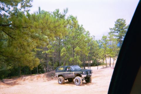 1985 Ford Bronco - This modified SUV, likely from the early 1980s, is seen off-road.