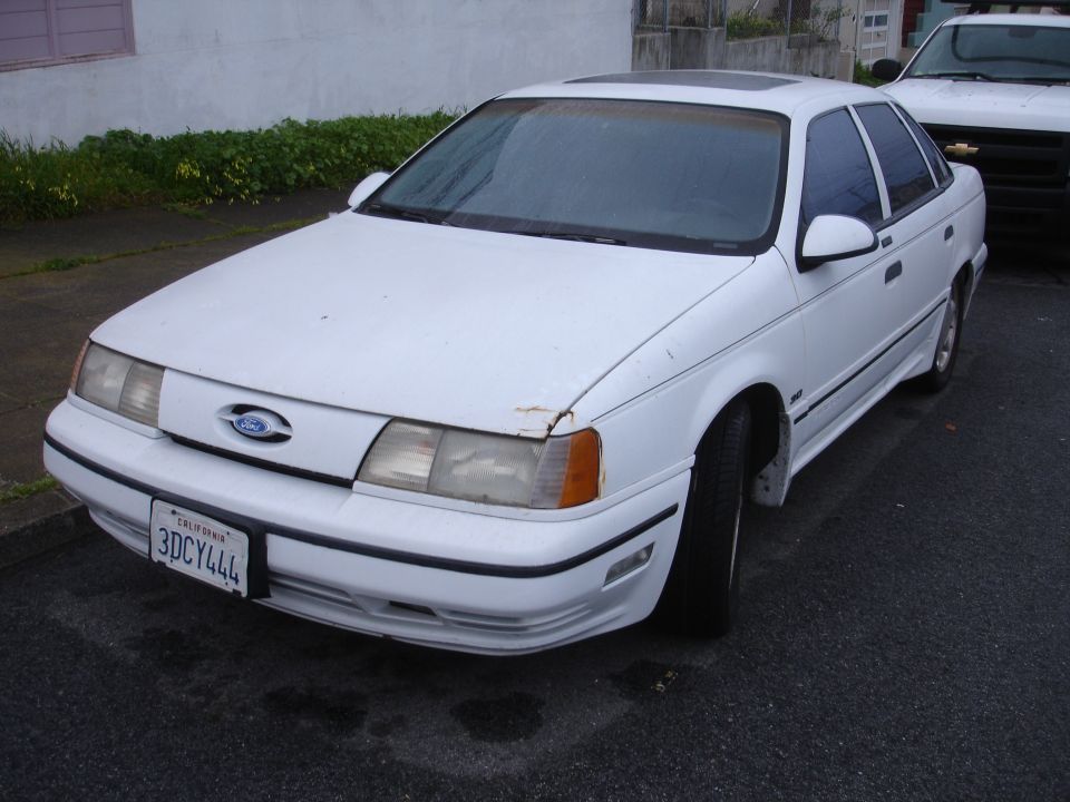 White 1989 Ford Taurus sedan, front 3/4 view. California license plate 3DCY444