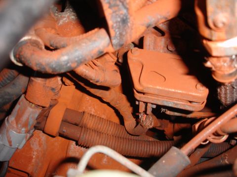 1989 Ford Taurus - The engine bay is heavily coated in orange dust, obscuring details of the components and wiring.