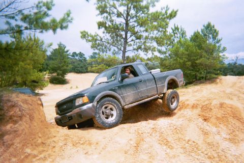 1985 Ford Bronco - Ford Ranger pickup truck navigates a challenging sandy terrain during an off-road excursion.