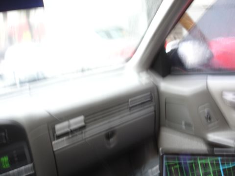 1989 Ford Taurus - View from inside a vehicle, showing the dashboard and a screen with a grid pattern.