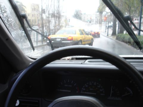 1989 Ford Taurus - A yellow taxi is seen from the interior of another vehicle on a rainy day.